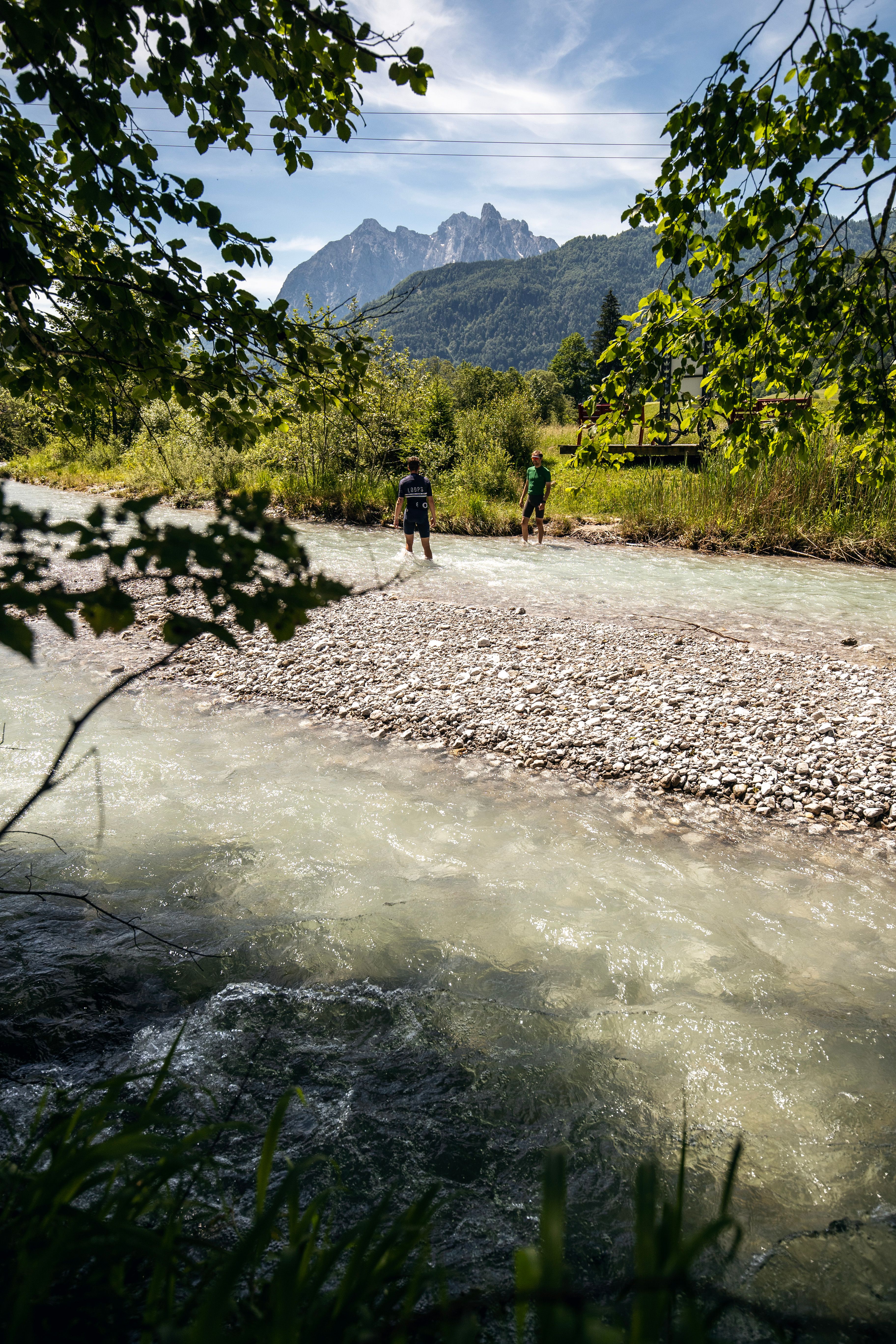 Abkühlung bei einer Gravelbike-Tour in einem Alpenfluss in Tirol, Österreich
