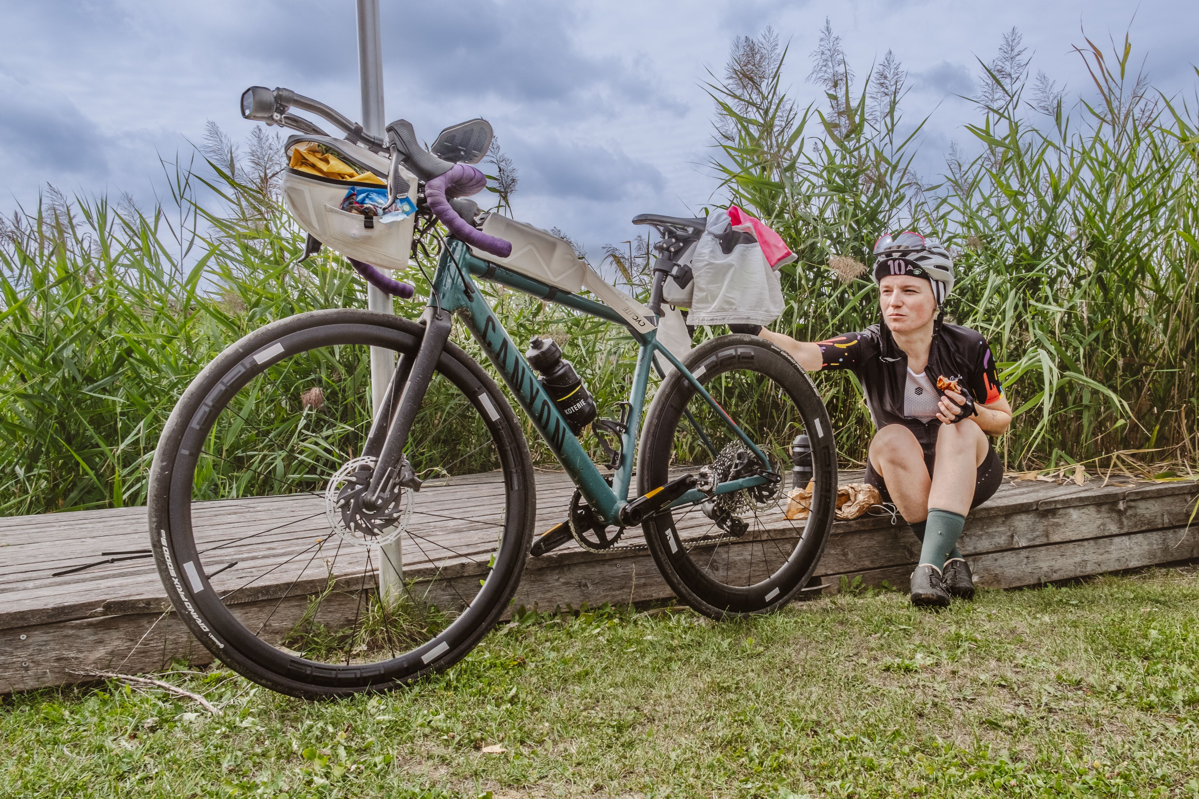 Eva Mader macht eine Pause am Falschen Meer während des The LOOP Bikepacking-Events mit Start in Wien.