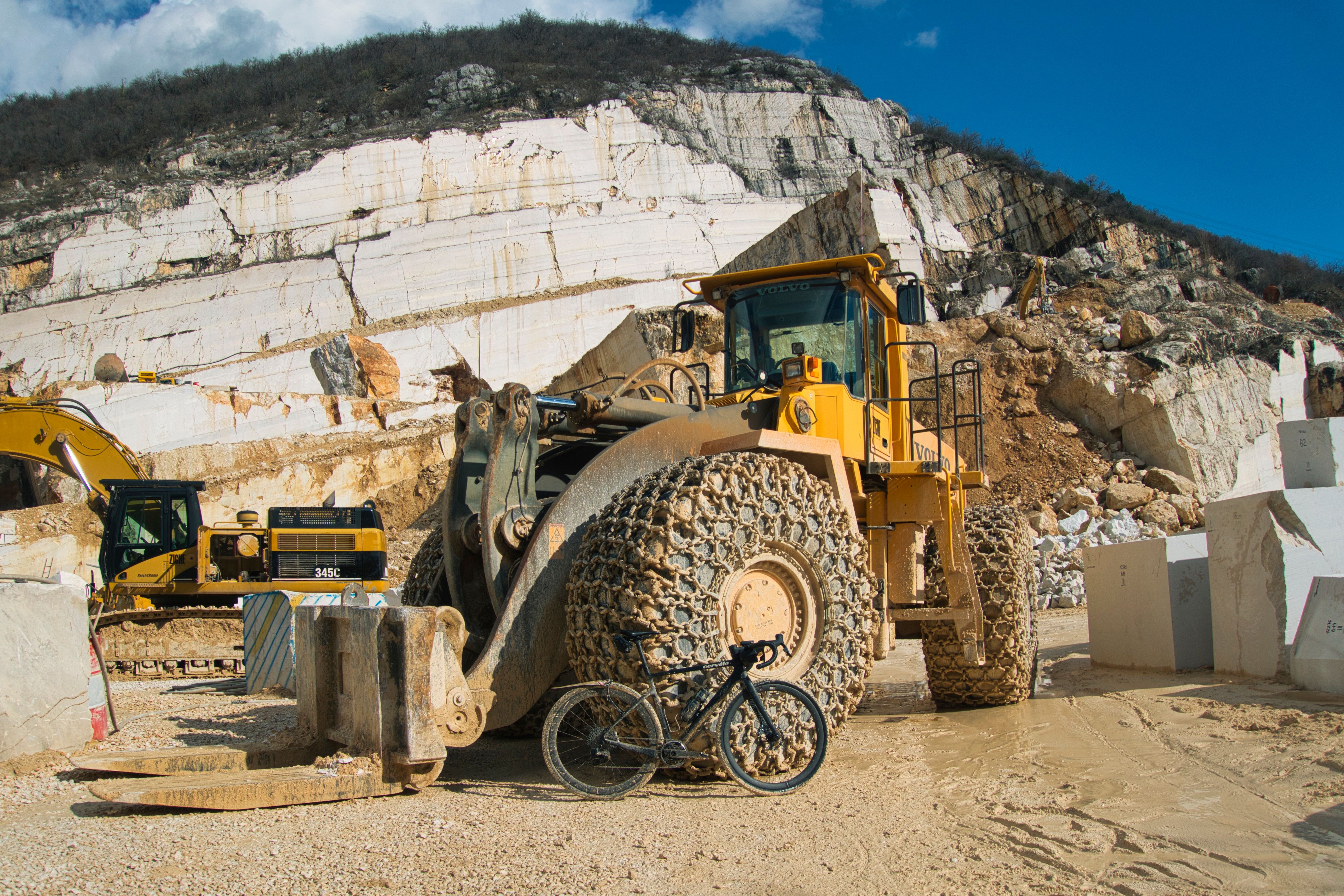 Bikes and heavy mining machinery at Marmöl Gravel in Brescia.
