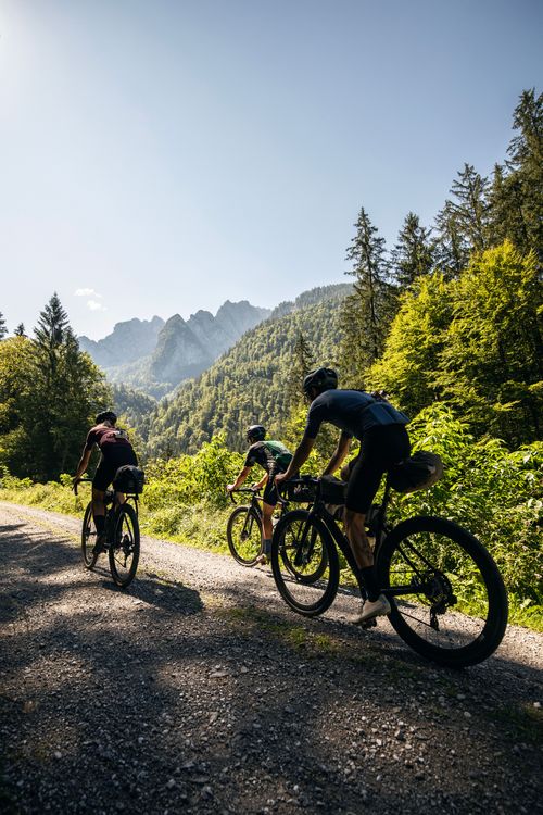 The Tennengebirge mountains are towering above us while we ride our gravelbikes along the lammer river in Salzburg, Austria.