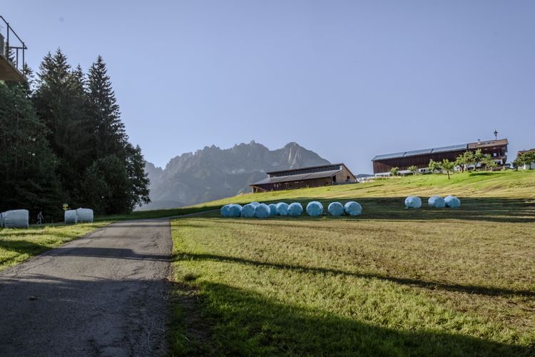 Green farmlands surrounded by alpine mountain landscapes await cyclists in the Kitzbühel Alps.