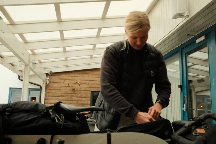 Henna packing her bike including her skimountaineering gear and splitboard.